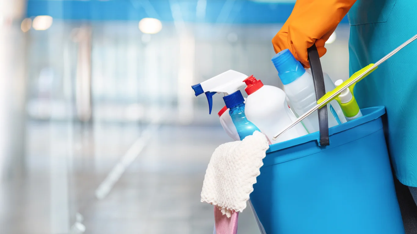 A Maraki cleaner carrying a bucket of professional cleaning supplies